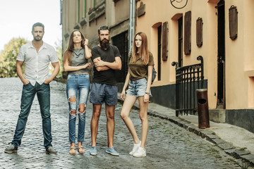 Obraz premium Young, stylish, fashionable friends standing on brick road