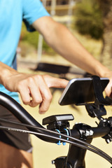 Obraz na płótnie Canvas young man using a smartphone riding a bicycle