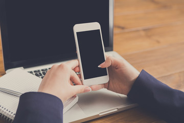 Close-up of woman using laptop and smartphone