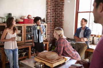 Five happy friends talking in kitchen, selective focus