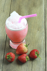Strawberry juice in Glass on wooden table floor.
