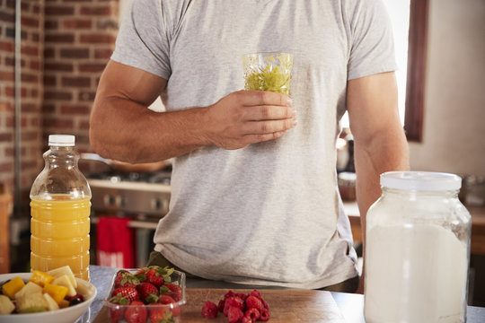 Man holding holding homemade smoothie, mid section