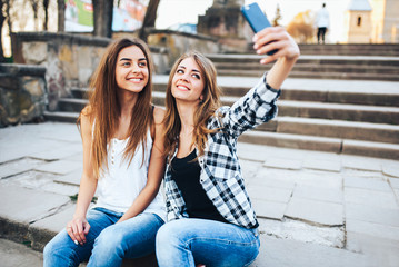 Two pretty girls making selfie in the park