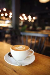 Zelfklevend Fotobehang cappuccino coffee on wood background © Oran Tantapakul