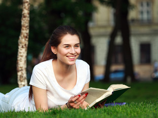 Obraz premium Happy girl student in city park with a book