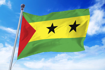 Flag of Sao Tomé and Príncipe developing against a clear blue sky