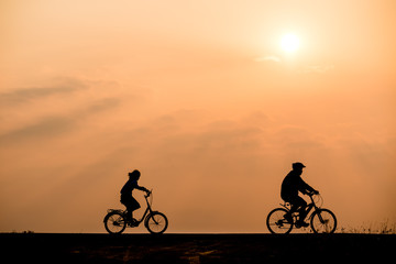 Plakat Silhouette of cyclist on sunset background