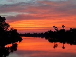 Obraz na płótnie Canvas sunsets behind the pond.