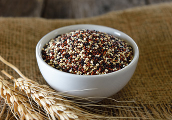 Quinoa seeds in bowl on wood