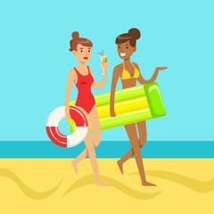 Two young women walking on the beach holding lifebuoy and floating mattress