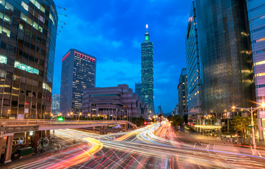Fototapeta premium Downtown Taipei City with busy traffic trails at rush hour ~ Beautiful night scenery of Taipei 101 Tower & World Trade Center buildings in XinYi Financial District