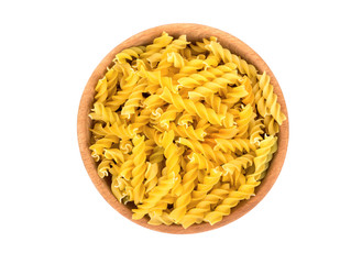 Uncooked pasta fusilli in a wooden bowl on a white background, top view