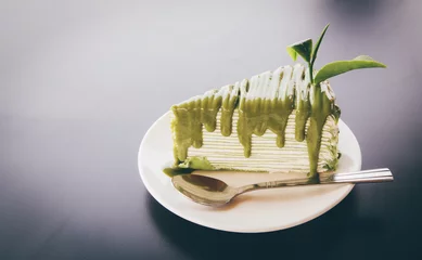  Close up Green tea cake on white disk with matcha green tea on the black wooden, sweet food of dessert Green tea cake. background space for texture. © noombluesman