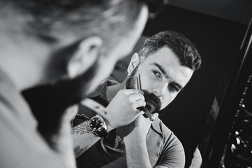 Cute bearded man shearing or shaving his beard. Fashion on the beard