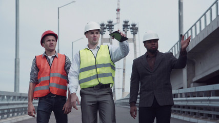 4K shot of Diverse group of three handsome male construction engineers with serious expressions...