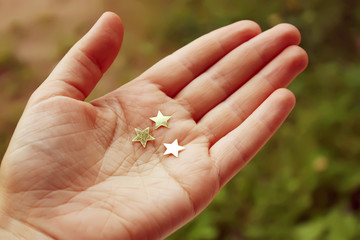 Hand with decorative golden paper stars