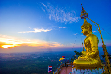Big golden Buddha on the hill top in the early morning time