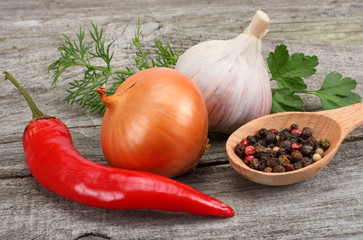 spices, onion, garlic and chili pepper on old wood background