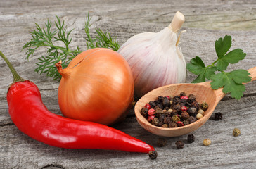 spices, onion, garlic and chili pepper on old wood background
