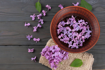 Obraz na płótnie Canvas lilac flower on dark wooden background. top view