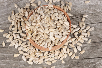 Sunflower seeds in bowl on old wooden table