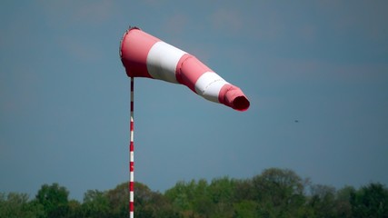 Waving airport weather vane or striped wind flag telephoto lens shot