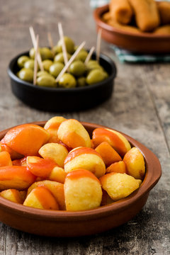 Traditional spanish tapas. Croquettes, olives and patatas bravas on wooden table

