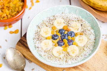 Avocado and Banana Smoothie Bowl with Blueberries, Coconut Flakes and Raisins, Close Up View