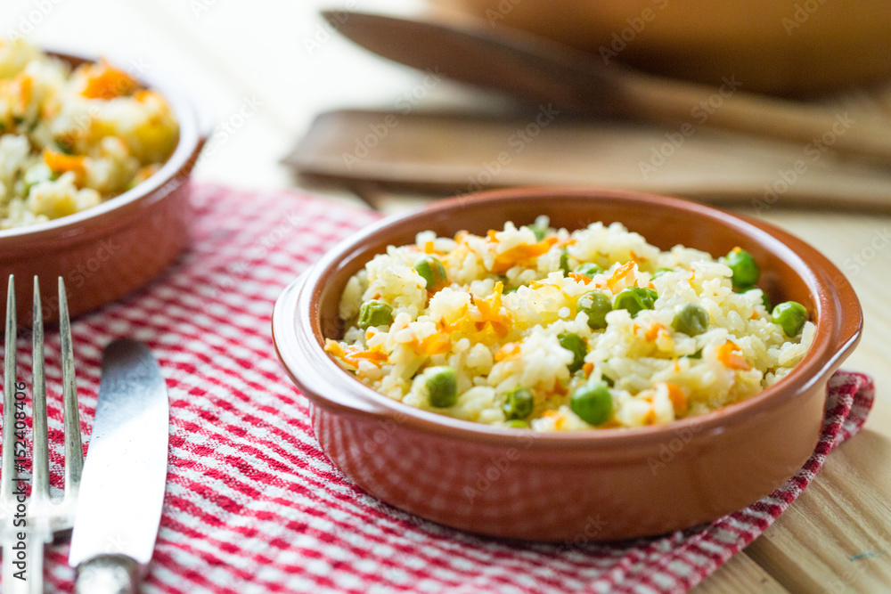 Wall mural Healthy Rice with Carrot and Peas on Light Wooden Background