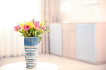 Vase with bouquet of beautiful tulips on table