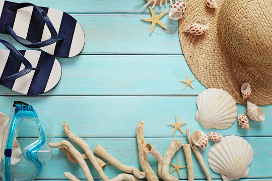 summer accessories and seashells on wooden board