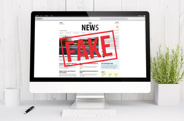 white workspace with fake news websiteon screen