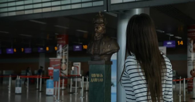 Woman looking at timetable departure board at international airport