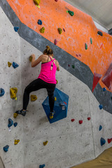 Girl climbing a boulder wall