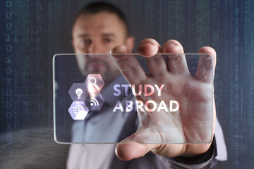 Business, Technology, Internet and network concept. Young businessman working on a virtual screen of the future and sees the inscription: Study abroad