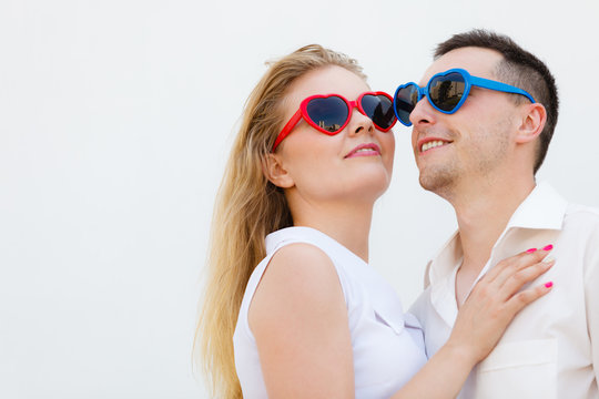 Man and woman wearing heart shape sunglasses