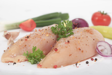 Raw chicken breast with spices and vegetables ready to prepare the meal 