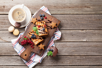 Coffee, sweets and waffles with berries