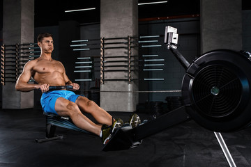 Fototapeta na wymiar Bodybuilder working on his legs with weight machine at the gym