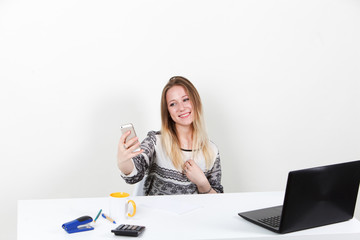 Girl office worker doing selfie at work. On a white background.