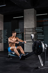 Obraz na płótnie Canvas Bodybuilder working on his legs with weight machine at the gym