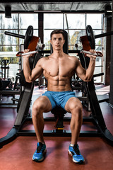 Fototapeta na wymiar Tense muscles of hands under load. Man doing exercise for biceps in the gym.