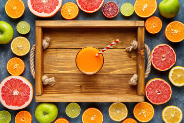 Smoothie or fresh juice in wooden tray in citrus fruits background flat lay, healthy lifestyle...