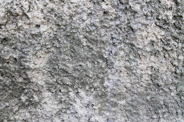 Artistic concrete texture for a background in black, gray and white colors with gravel drops close-up. The relief wall of the house, like the texture for construction