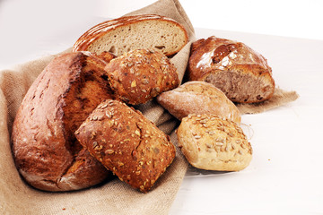 Different kinds of bread and bread rolls on board from above. Kitchen or bakery poster design.