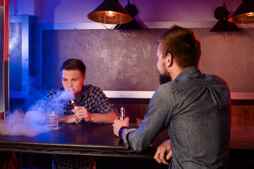 Vaping man holding a mod. A cloud of vapor at the vapebar.