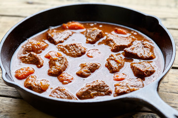 Goulash traditional Hungarian beef stew soup meat food in cast iron pan homemade meal with paprika