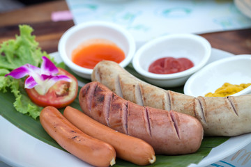 Grilled sausages and vegetables. Grilled pork sausages. Sausages serve with spicy sauce.Delicious german sausages.(selective focus)