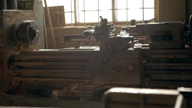 Footage in slowmotion of woodwork machine standing in joinery. Sawdust flying in air