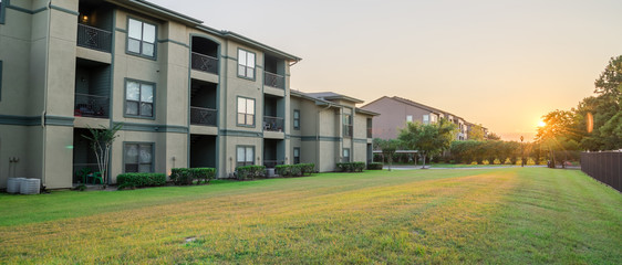 View from grassy backyard of a typical apartment complex building in suburban area at Humble,...